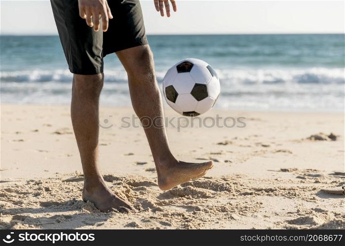 male tossing ball up playing game beach