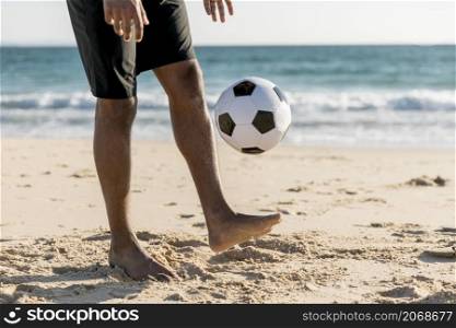 male tossing ball up playing game beach