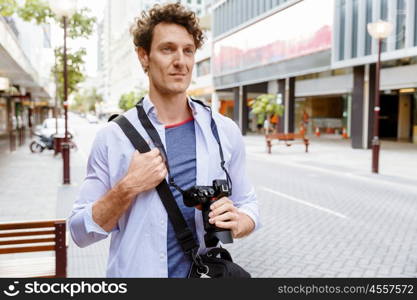 Male tourist in city. Happy male tourist in casual clothes in city walking