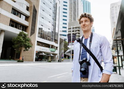 Male tourist in city. Happy male tourist in casual clothes in city walking