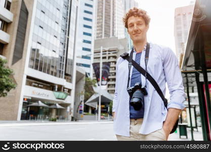 Male tourist in city. Happy male tourist in casual clothes in city walking