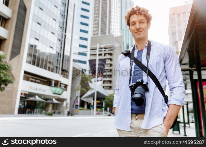 Male tourist in city. Happy male tourist in casual clothes in city walking