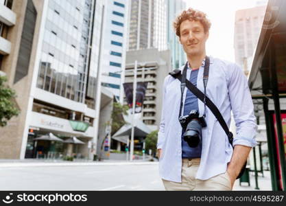 Male tourist in city. Happy male tourist in casual clothes in city walking