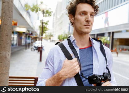 Male tourist in city. Happy male tourist in casual clothes in city walking