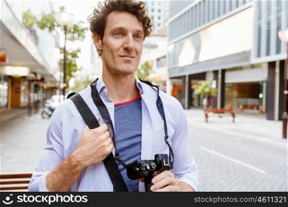 Male tourist in city. Happy male tourist in casual clothes in city walking