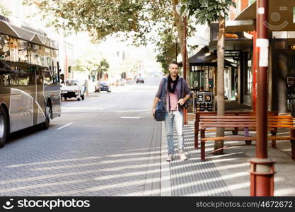 Male tourist in city. Happy male tourist in casual clothes in city walking