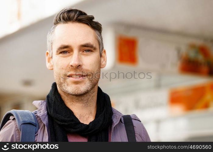 Male tourist in city. Happy male tourist in casual clothes in city walking