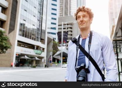 Male tourist in city. Happy male tourist in casual clothes in city walking