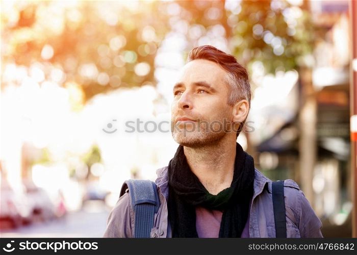 Male tourist in city. Happy male tourist in casual clothes in city walking