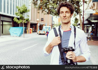 Male tourist in city. Happy male tourist in casual clothes in city walking