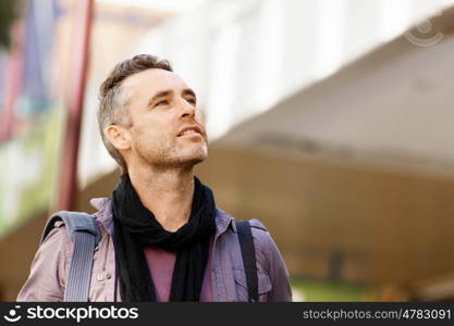 Male tourist in city. Happy male tourist in casual clothes in city walking