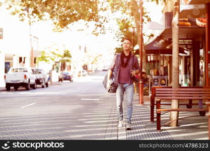 Male tourist in city. Happy male tourist in casual clothes in city walking