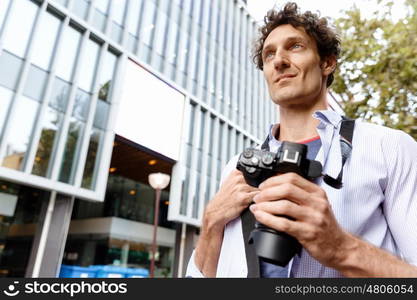 Male tourist in city. Happy male tourist in casual clothes in city walking