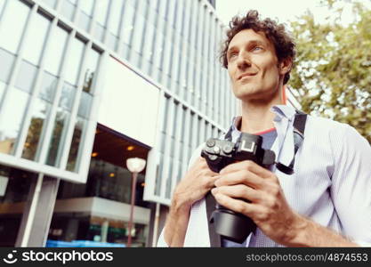 Male tourist in city. Happy male tourist in casual clothes in city walking