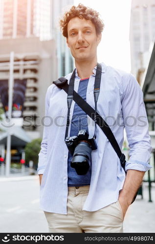 Male tourist in city. Happy male tourist in casual clothes in city walking