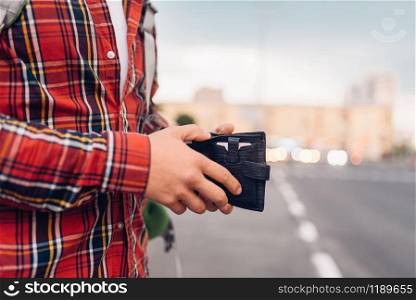 Male tourist with wallet at bus stop. Summer travelling, hike adventure over sightseeing, city walking, hiking concept