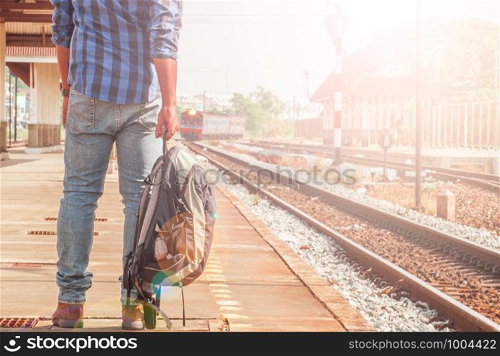 Male tourists are carrying luggage waiting train on the platform. Photo light and adjustable tone vintage