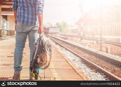 Male tourists are carrying luggage waiting train on the platform. Photo light and adjustable tone vintage