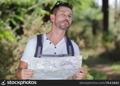 male traveler holding a map looking for direction