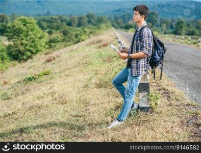 Male traveler with a backpack Holding a map and standing near to a kilometer.