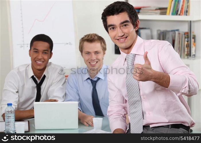 male trio in meeting room with laptop
