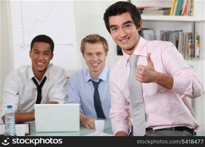male trio in meeting room with laptop