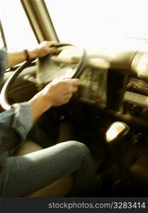 Male truck driver&acute;s hands holding steering wheel .