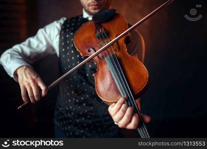 Male violinist playing classical music on violin. Fiddler man with musical instrument. Male violinist playing classical music on violin