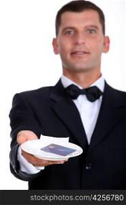 Male waiter holding credit-card and receipt
