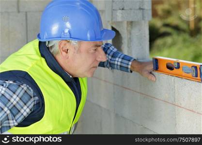 male worker fixing a wall at a construction site