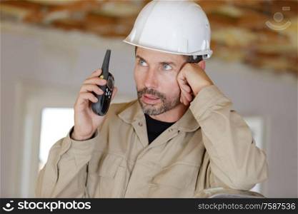 male worker in helmet with walkie talkie