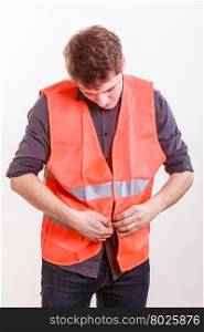 Male worker in safety vest.. Job and work concept. Young handsome worker wearing orange uniform safety vest. Repairman inspector at work.