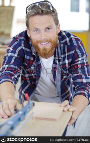 male worker sanded piece of wood in the studio