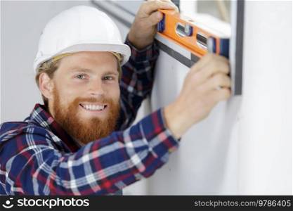 male worker taking measurements of window in flat
