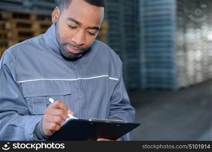 Male worker writing on clipboard