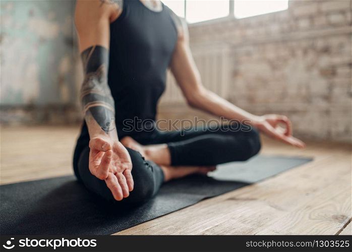 Male yoga, meditation in asana position, full relaxation. Fit workout indoors, yogi studio. Male yoga, meditation in asana position