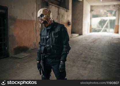 Male zombie walking in abandoned factory, scary place. Horror in city, creepy crawlies attack, doomsday apocalypse, bloody evil monsters. Male zombie walking in abandoned factory