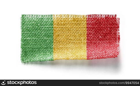 Mali flag on a piece of cloth on a white background.. Mali flag on a piece of cloth on a white background