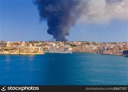 Malta. Fire at the waste-processing plant Sant Antnin.. A huge pillar of black smoke over bay of the city Valletta due to a fire at Sant Antnin recycling plant.