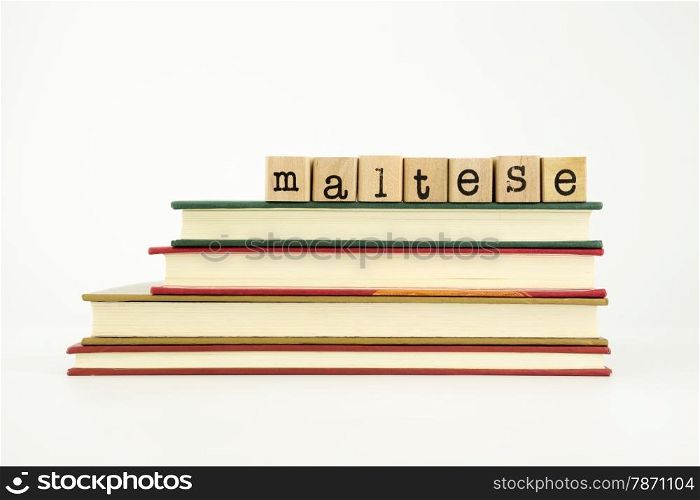 maltese word on wood stamps stack on books, foreign language and translation concept