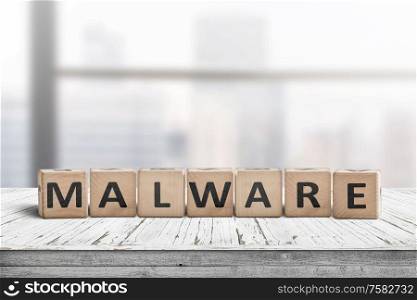 Malware message sign made of wood on a desk in a bright office environment