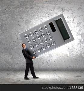 Man accountant. Young businessman carrying huge calculator in hands