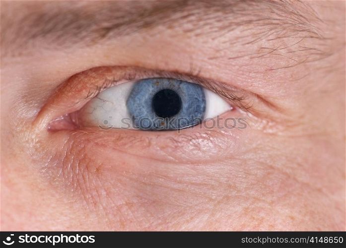 Man&acute;s blue eye. Close up macro portrait