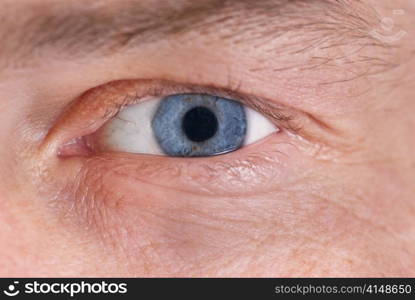 Man&acute;s blue eye. Close up macro portrait