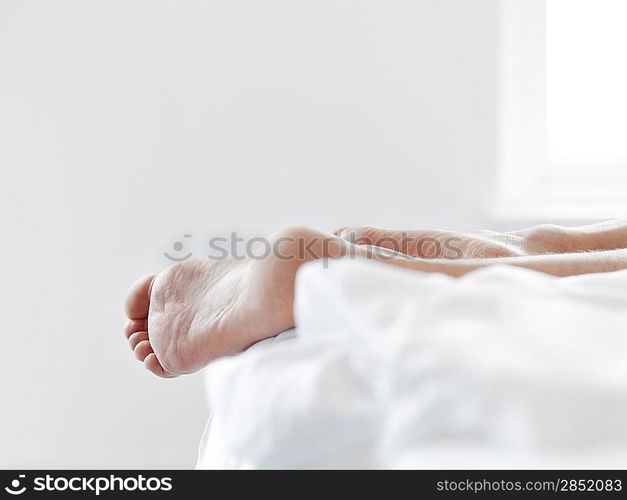 Man&acute;s Feet on Bed