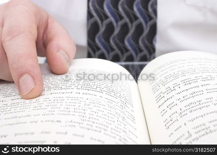 Man&acute;s Hand On Open Book: Close up of man pointing to page in open book.