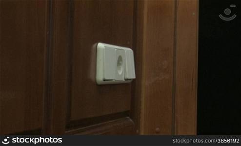 man&acute;s hand switches off light in a room.