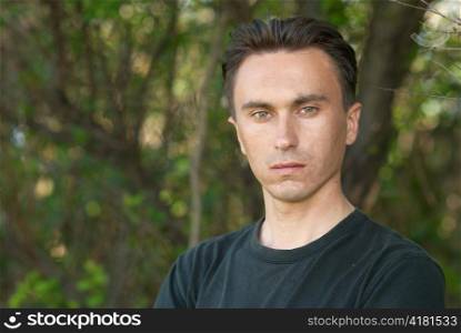 Man&acute;s portrait in the soft forest background