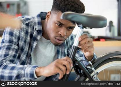 man adjusting the saddle on his bicycle