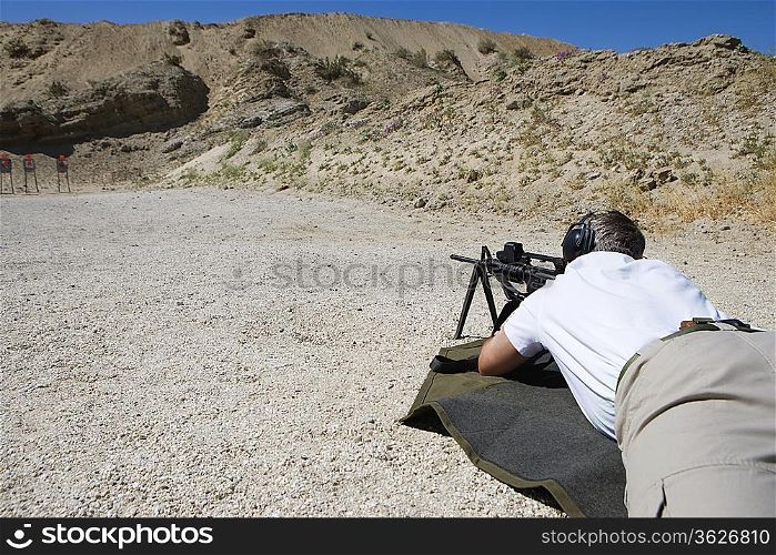 Man aiming machine gun at firing range